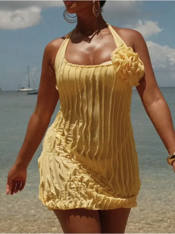 Yellow halter floral pleated mini dress walking outdoors