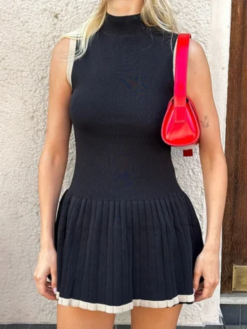 Half high collar sleeveless black mini dress styled with red bag and boots