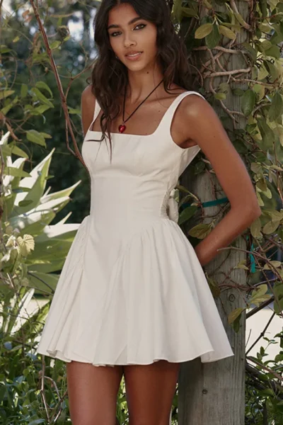 legant backless bow mini dress in white outdoor scene